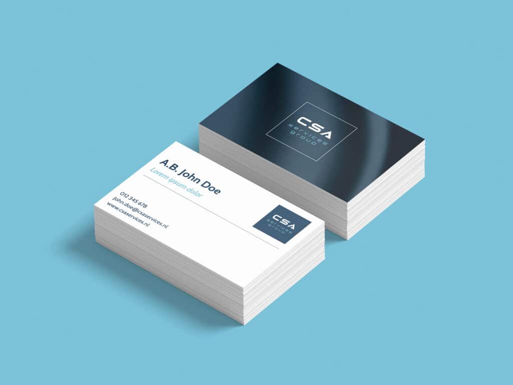 Dubbele visitekaartjes met modern blauw-wit ontwerp voor CSA Services Group, gepresenteerd op een turquoise achtergrond.
